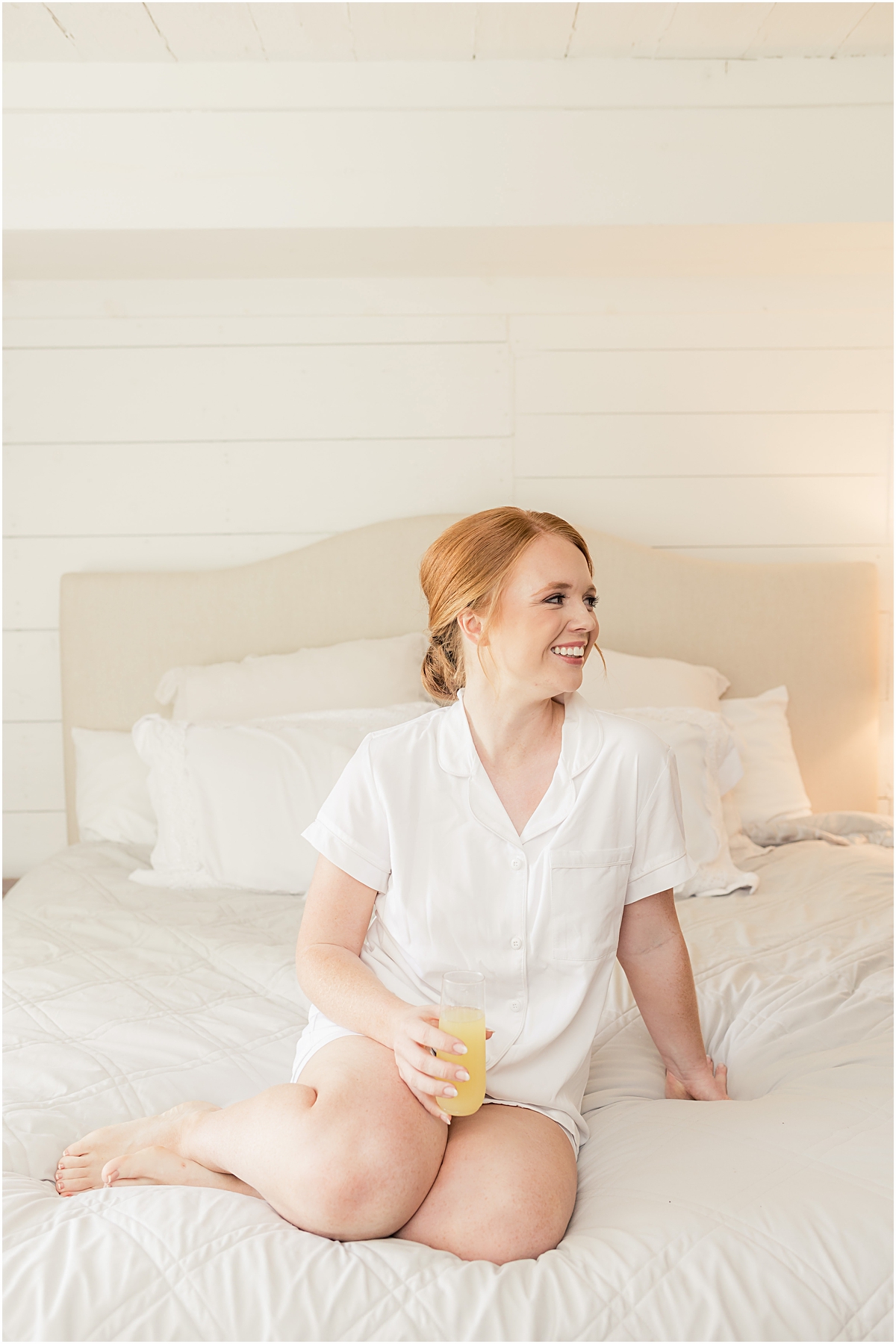 Bride in a white shirt on a bed 