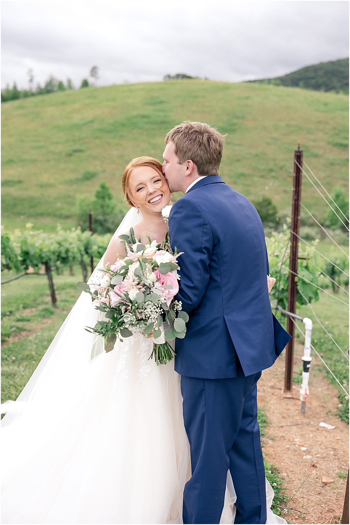 Wedding portrait of Davis nuzzling GRace in the vineyard