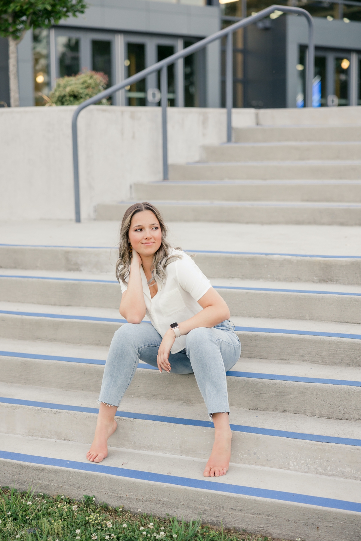 A woman sitting on the stairs of the UNG stadium during her graduate session