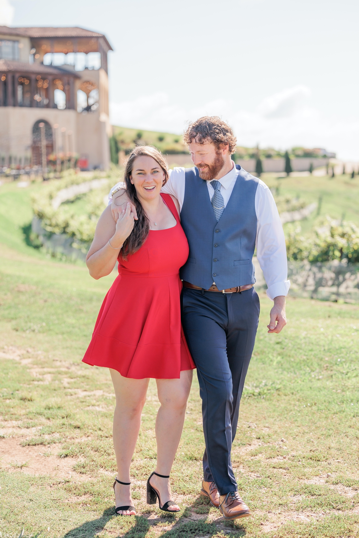 Matthew and Rachel walking with his arm over her shoulder during their session at Montaluce Winery.