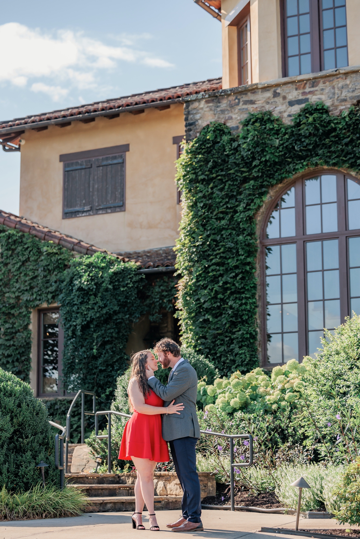 Rachel and Matthew kissing in front of the winery house during their Montaluce Winery engagement session.
