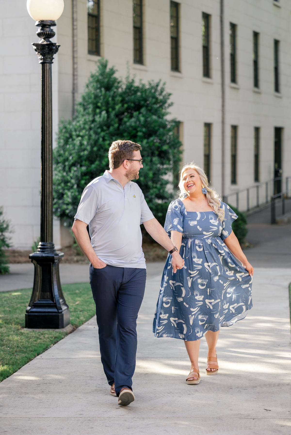 Austin looking back at Sydney while he leads her across the Atlanta Athletic Club campus during their engagement session.