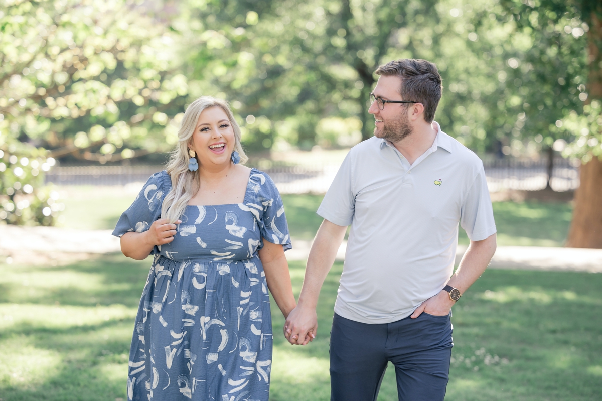 Austin and Sydney walking and laughing hand in hand during their engagement session.