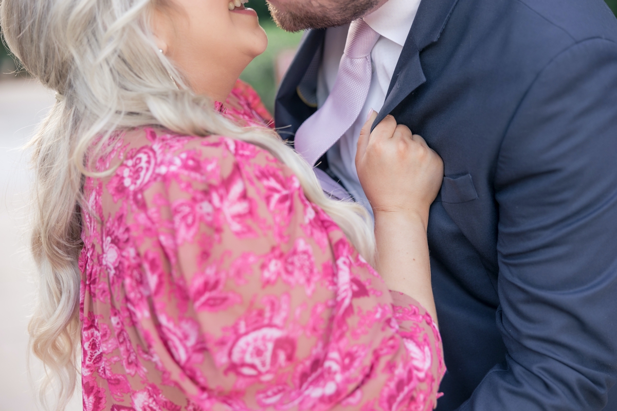Detail photo of Sydney grabbing Austin's lapel while she pulls him in for a kiss during their engagement session.
