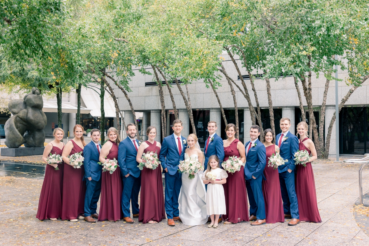Rebecca and Josh smiling with their wedding party at Foundry Puritan Mill.