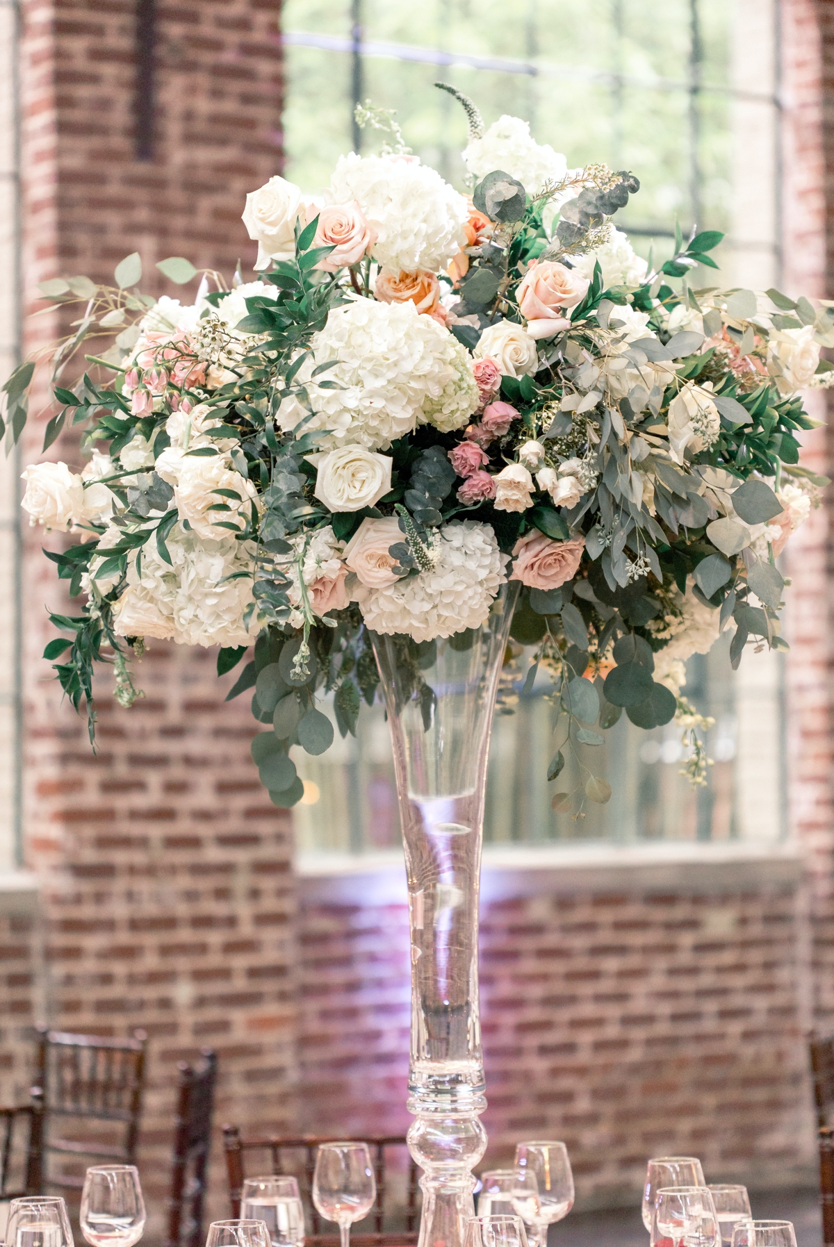 A white and blush raised floral centerpiece at The Schneider wedding at Foundry Puritan Mill.