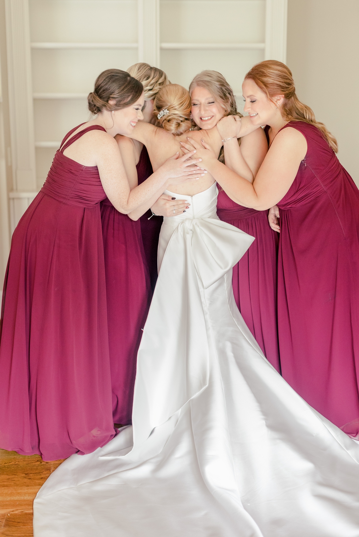 Rebecca hugging her bridesmaids after their first look at Foundry Puritan Mill.