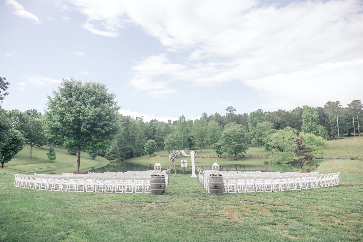 A pulled back look at Chris and Grace's wedding ceremony sett up on the edge of a pond at Walters Barn in Lula GA