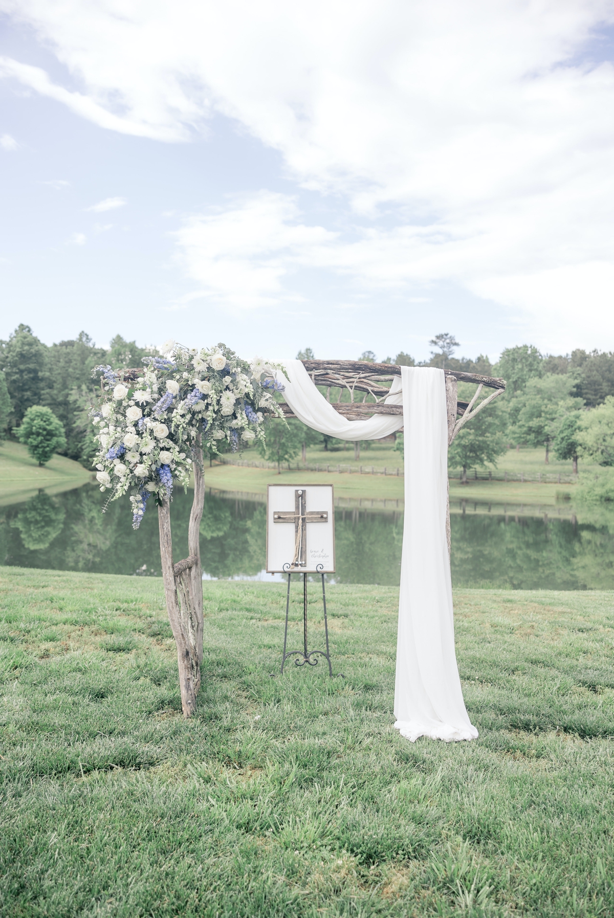 Detail photo of Chris and Grace's wedding day arch set up on the edge of a pond at Walters Barn.