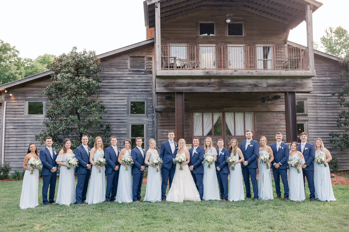 Chris and Grace with their wedding party in front of Walters Barn on their wedding day.