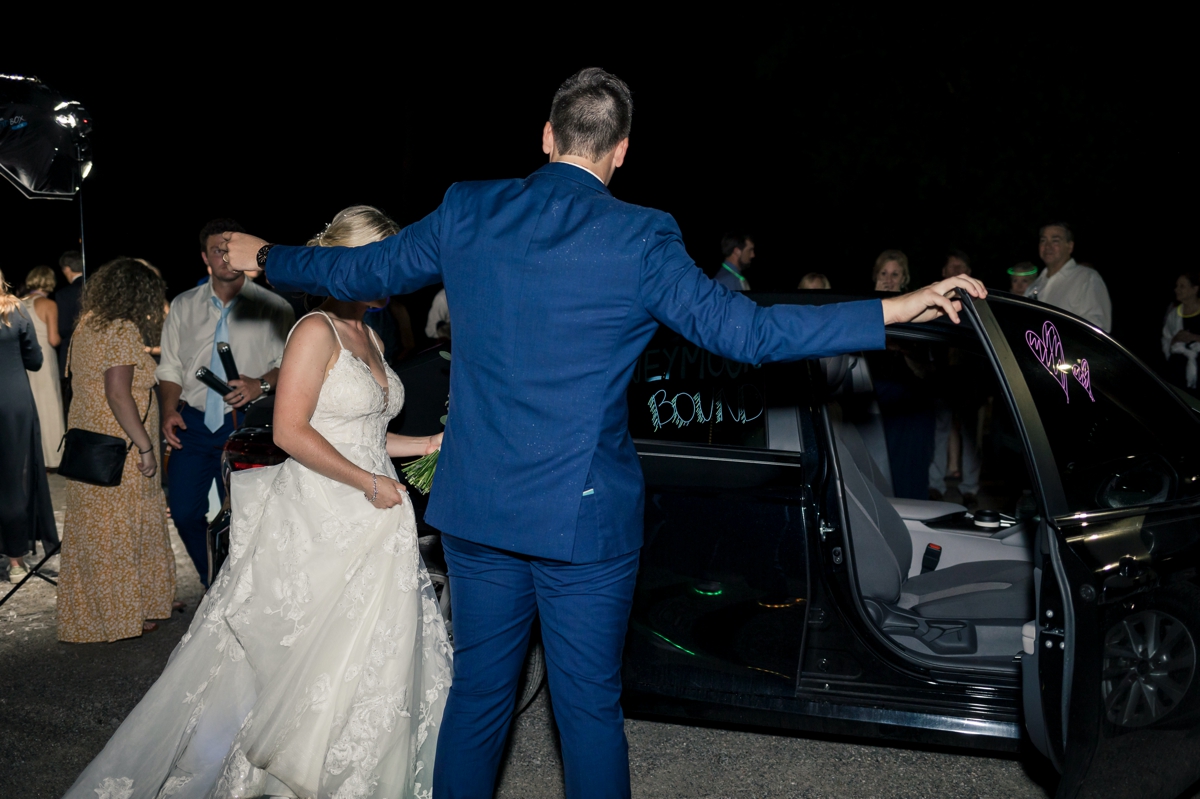 Chris helping his bride into the getaway car during their wedding day exit.