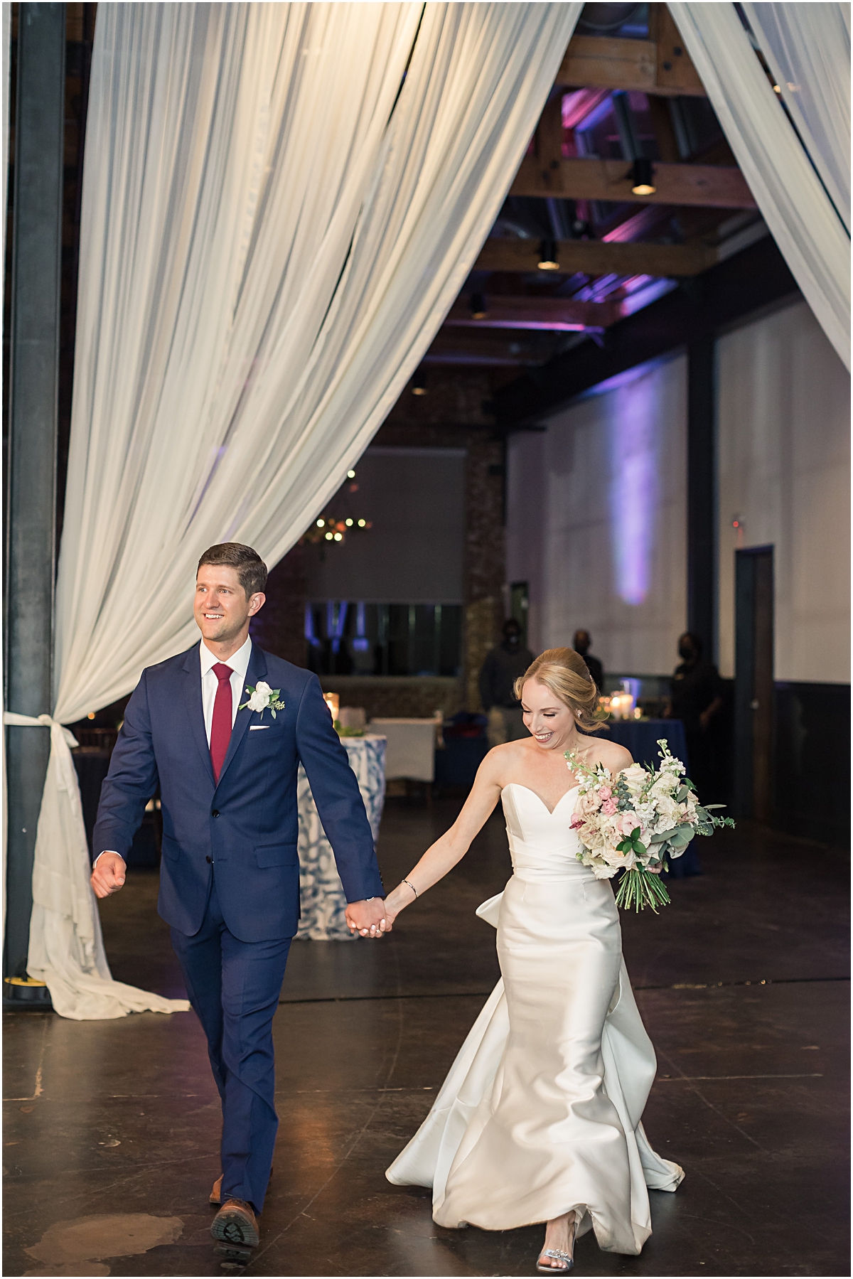 Rebecca + John walking into their reception at The Foundry at Puritan Mill