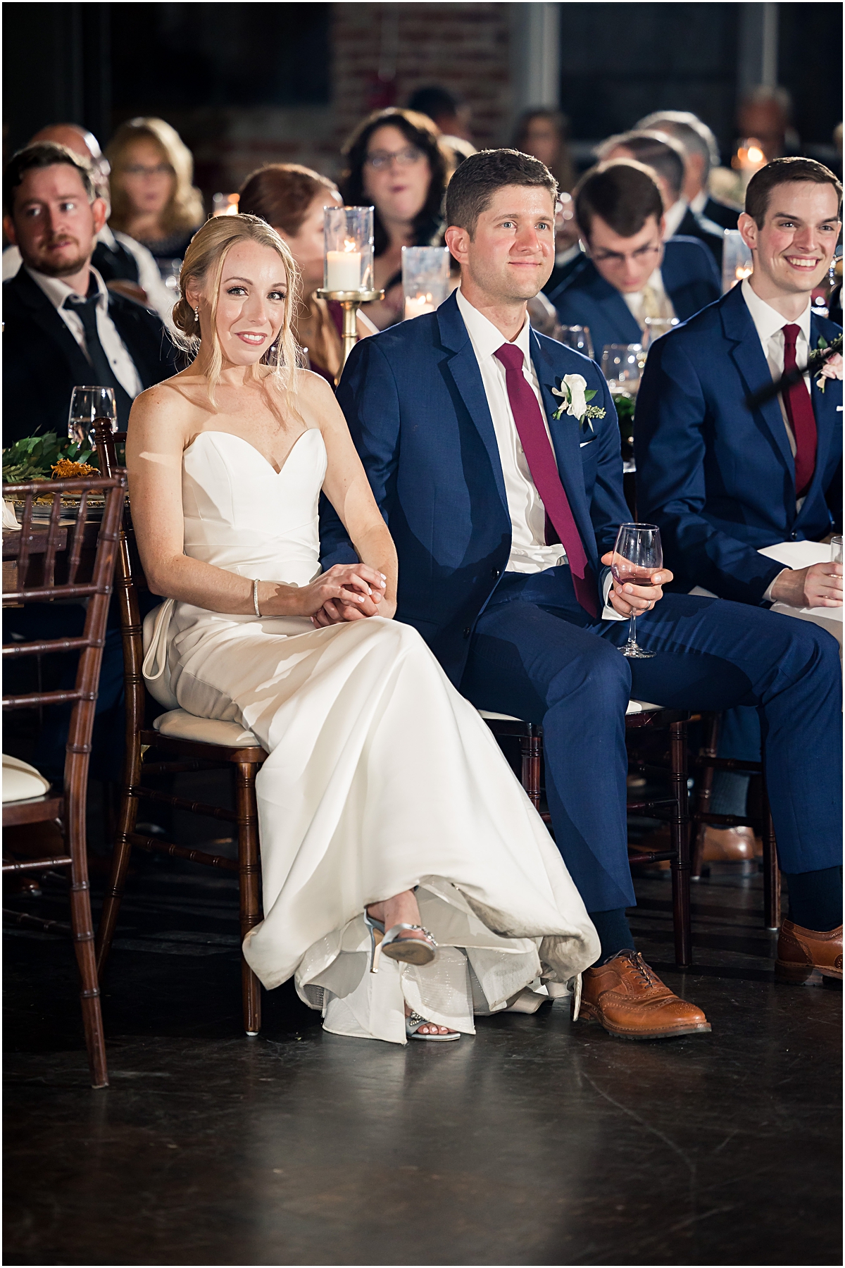 Rebecca and John listening to speeches during their reception at the foundry at puritan mill in georgia